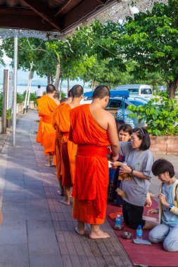 PHAYAO, THAILAND - 9 Temmuz 2016: Tayland halkı Phayao 'daki Kwan Phayao Gölü' nün yanındaki Budist rahiplere yemek sunuyor.