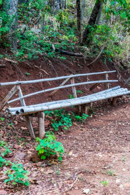 Yürüme yolunun yanındaki basit bambu bank, Tayland.