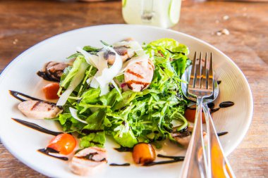 Beyaz tabak üzerinde İtalyan sosisi ve roket salatası, Tayland.