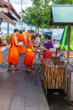 PHAYAO, THAILAND - 9 Temmuz 2016: Tayland halkı Phayao 'daki Kwan Phayao Gölü' nün yanındaki Budist rahiplere yemek sunuyor.