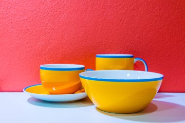 Tabak ve bardaklar turuncu duvar ve beyaz zemin, Tayland.