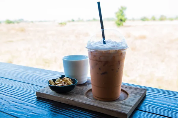 Iced Milk Tea with biscuit on Wooden Table, Thailand