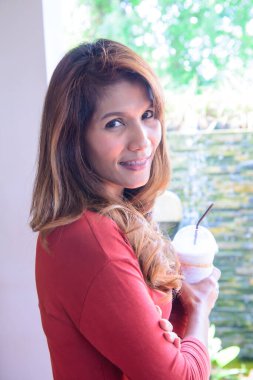 Taylandlı bir kadın, Tayland 'da bir kafede buzlu kahve tutuyor..