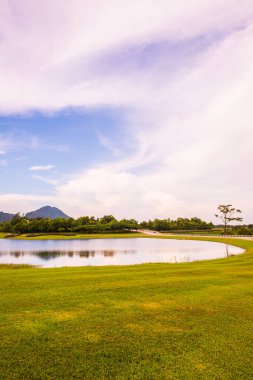 Gölü olan yeşil çimenlik alan, Tayland.
