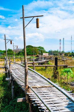 The wooden bridge with rice field at Phrathat San Don temple, Lampang province.