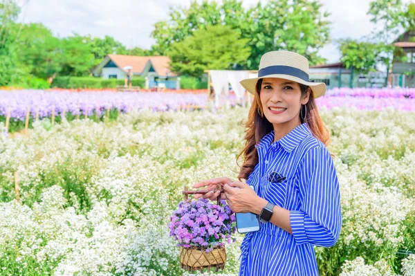 Thai Woman in Beautiful Flower Garden at Chiang Mai Province, Thailand.