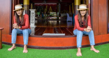 Pamorama of twin Asian women with old building background at Phayao province, Thailand.