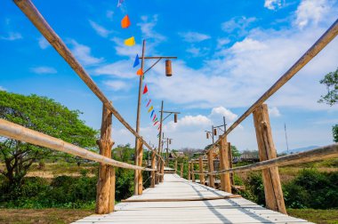 The wooden bridge with rice field at Phrathat San Don temple, Lampang province.