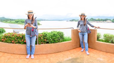 Twin Women Traveler with Golden Triangle Background, Chiang Rai Province.