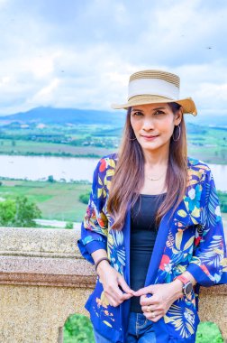 A Woman Traveler with Mekong River Background at Chiang Saen District, Chiang Rai Province.