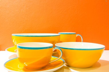 Tabaklar, tabaklar ve bardaklar turuncu duvarlı ve beyaz zemin, Tayland.