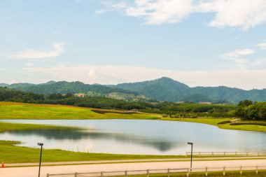 Gölü olan yeşil çimenlik alan, Tayland.