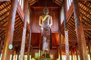 CHIANG MAI, THAILAND - March 21, 2021 : The Wooden Standing Buddha of Wat Luang Khun Win in Chiangmai Province, Thailand.