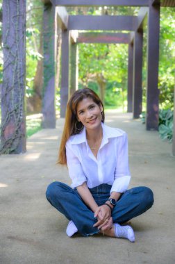 Asian woman wearing white shirt in the park, Chiang Mai Province.