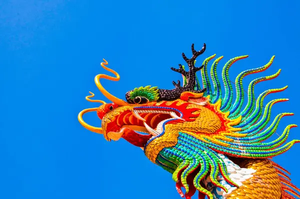 Head shot of colorful dragon statue with blue sky at public park, Thailand.