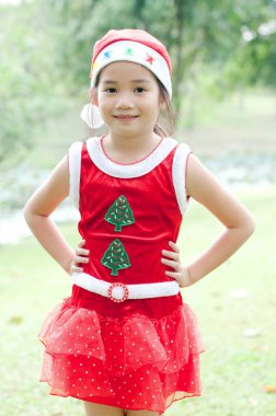 Tayland 'da Noel Baba şapkalı ve kırmızı elbiseli güzel bir genç kız..