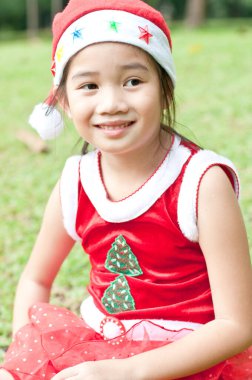 Tayland 'da Noel Baba şapkalı ve kırmızı elbiseli güzel bir genç kız..