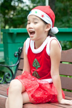 Tayland 'da Noel Baba şapkalı ve kırmızı elbiseli güzel bir genç kız..