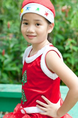 Tayland 'da Noel Baba şapkalı ve kırmızı elbiseli güzel bir genç kız..