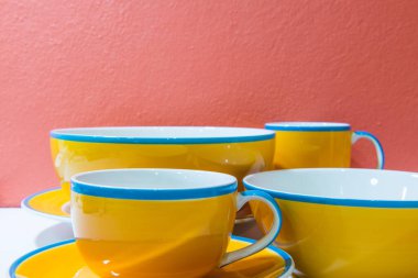 Tabaklar, tabaklar ve bardaklar turuncu duvarlı ve beyaz zemin, Tayland.