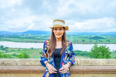 A Woman Traveler with Mekong River Background at Chiang Saen District, Chiang Rai Province.