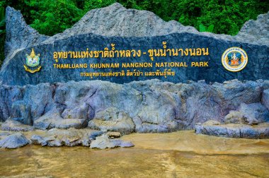 CHIANG RAI, THAILAND - July 18, 2020 : Thamluang Khunnam Nangnon National Park entrance sign with stone surrounding and trees, Thailand.
