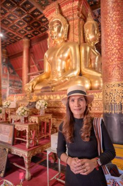 Asian Woman in Black Dress with Wat Phumin Background, Nan Province.