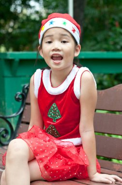 Tayland 'da Noel Baba şapkalı ve kırmızı elbiseli güzel bir genç kız..