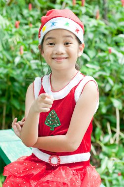 Tayland 'da Noel Baba şapkalı ve kırmızı elbiseli güzel bir genç kız..