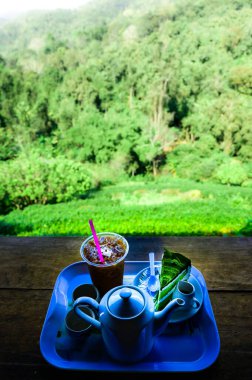 İçki seti ve kekler beyaz seramik tepside ve dağ manzaralı Chiang Mai Eyaleti, Tayland.