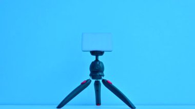 Mini tripod ve mavi duvar arkaplanındaki aydınlatma ışık kutusu.