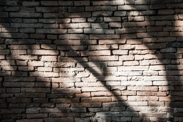 Old brick wall with black shadow, Thailand.