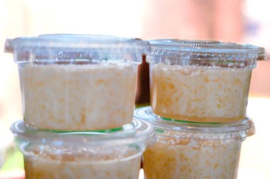 Thai sweet fermented rice or Khao Mak in plastic cup. Khao Mak is a type of Thai dessert, It is made from steaming glutinous rice and then fermenting it with mold and yeast in the form of flour. clipart