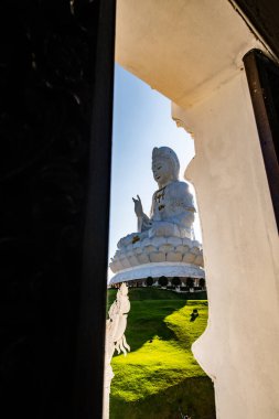 Guan Yin statue in window frame, Thailand. clipart
