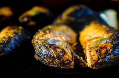 Yemek tezgahında kızarmış uskumru. Kızarmış uskumru Taylandlıların acı biber ezmesiyle yemeyi sevdiği bir yemektir..