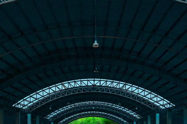 stock image Truss curved roof with skylight. Metal sheet roof and truss structure. Curved roof of and truss structure. Truss curved roof with tree viewing window.