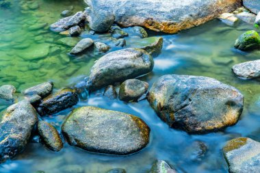 Su, Tayland 'ın Chiang Mai Eyaleti' nde kayaların içinden akıyor. Yüksek dağda küçük bir dere. Bir dağ deresinin güzel doğal detayları. Kuzey Tayland 'da dağ deresi.