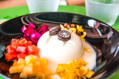 Meyveli soğuk tofu pudingi ve kara tabakta tatlı, Tayland.