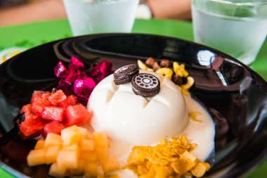 Meyveli soğuk tofu pudingi ve kara tabakta tatlı, Tayland.