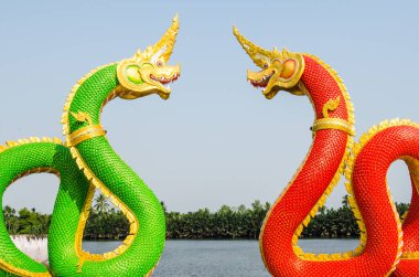Mavi gökyüzünde yeşil ve kırmızı Naga heykeli, Tayland