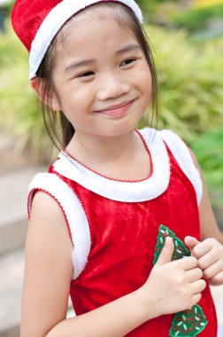 Tayland 'da Noel Baba şapkalı ve kırmızı elbiseli güzel bir genç kız..