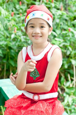 Tayland 'da Noel Baba şapkalı ve kırmızı elbiseli güzel bir genç kız..