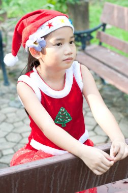 Tayland 'da Noel Baba şapkalı ve kırmızı elbiseli güzel bir genç kız..