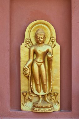 Kahverengi duvarda duran altın Buda, Tayland.