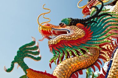 Tayland 'daki halk parkında mavi gökyüzü olan renkli ejderha heykelinin baş resmi..