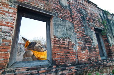 Tuğla duvarlı yaslanmış Buda heykeli, Tayland.