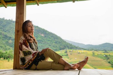 Asian Woman in Thai Native Pavilion with Rice Field Background at Pa Bong Piang Rice Terraces, Chiangmai Province.