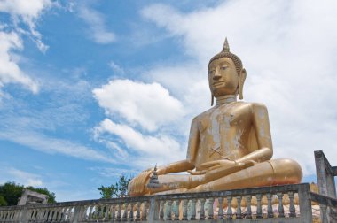 Mavi gökyüzü ile güzel altın Buda heykeli, Sra-ket tapınağı, Angthong Eyaleti, Tayland.