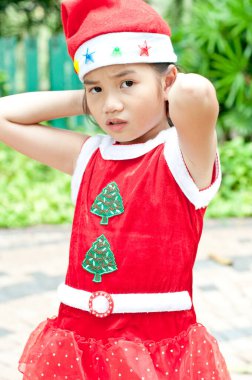 Tayland 'da Noel Baba şapkalı ve kırmızı elbiseli güzel bir genç kız..