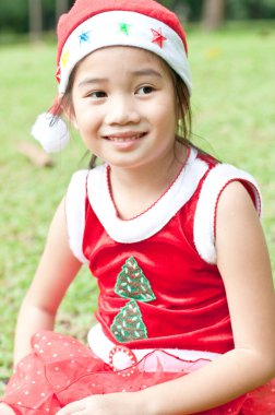 Tayland 'da Noel Baba şapkalı ve kırmızı elbiseli güzel bir genç kız..